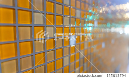 Abstract glass mosaic wall with warm yellow tiles. 135013794