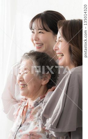 A close-up portrait of smiling three-generation women who feel a bond. The bond and affection between granddaughter, mother, and grandmother. 135014320
