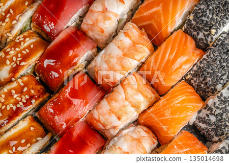 Assorted sushi rolls with salmon tuna shrimp and sesame close up Assorted sushi rolls with salmon tuna shrimp and sesame close up 135014698