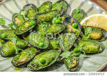 Mussels in green herb sauce with lemon and fresh microgreens on ceramic plate Mussels in green herb sauce with lemon and fresh microgreens on ceramic plate 135014717