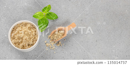 Basil flavored salt in bowl with wooden scoop on light background, top view, copy space Basil flavored salt in bowl with wooden scoop on light background, top view, copy space 135014737
