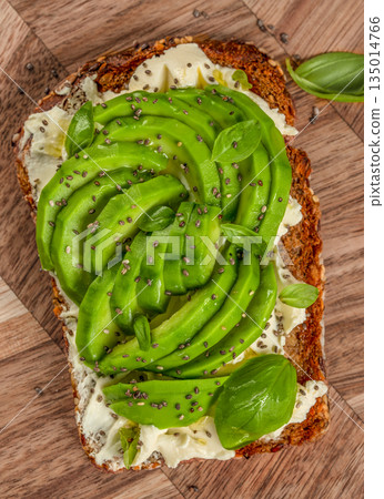Healthy avocado toast with cream cheese, chia seeds, and basil top view 135014766