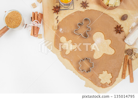 Gingerbread cookie dough with cutters, spices, and ingredients on kitchen table, top view, free space for text 135014795