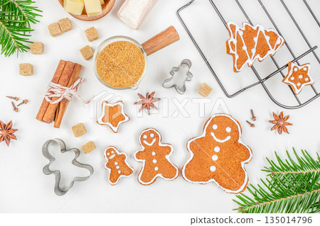 Gingerbread cookies with icing and Christmas spices on white background, top view, free space for text Gingerbread cookies with icing and Christmas spices on white background, top view, free space for text 135014796