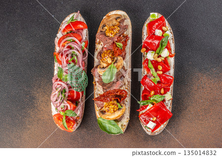 Assorted gourmet bruschetta with vegetables, mushrooms, and herbs on dark background Assorted gourmet bruschetta with vegetables, mushrooms, and herbs on dark background 135014832