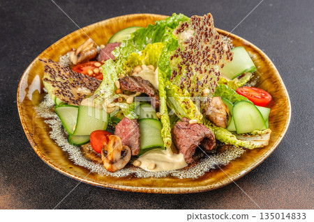 Gourmet salad with grilled beef, fresh vegetables, and crispy topping on rustic plate Gourmet salad with grilled beef, fresh vegetables, and crispy topping on rustic plate 135014833
