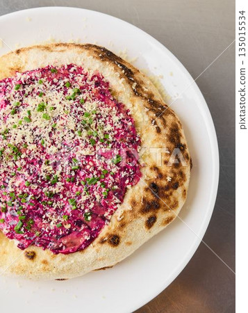 Macro image showcasing herbcrusted beet pizza with sesame seeds and parsley 135015534