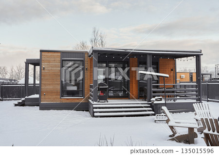 Remote winter cabin featuring wooden porch and cozy interior Remote winter cabin featuring wooden porch and cozy interior 135015596