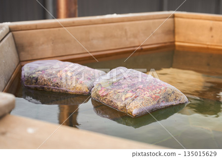Soothing Herbalfilled Pouches Gently Sway On Warm Water Within Wooden Tub For Calming Ritual 135015629