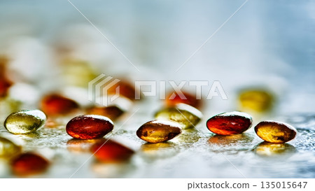 Shiny amber and red gelatin softgel capsules containing nutritional supplement for health wellness dietary needs everyday use benefits. AI Generated 135015647