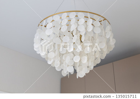 Stylish capiz shell chandelier creating cozy ambient lighting indoors Stylish capiz shell chandelier creating cozy ambient lighting indoors 135015711
