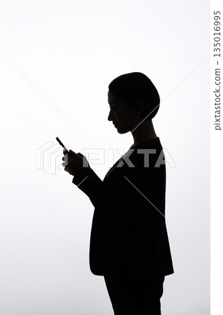 Woman operating a smartphone Woman operating a smartphone 135016995
