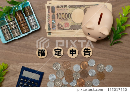Image of tax return, cash, and piggy bank Image of tax return, cash, and piggy bank 135017530