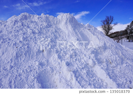 A pile of snow left behind after snow removal in a corner of the parking lot A pile of snow left behind after snow removal in a corner of the parking lot 135018370