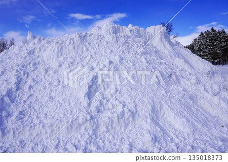 A pile of snow left behind after snow removal in a corner of the parking lot A pile of snow left behind after snow removal in a corner of the parking lot 135018373