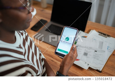 Person checking successful online banking payment on smartphone 135018472