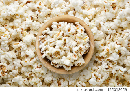 Popcorn in a wooden bowl background. Top view Popcorn in a wooden bowl background. Top view 135018659