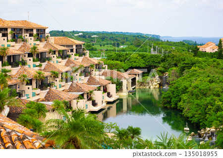 A luxury resort hotel and courtyard with vibrant palm trees against the refreshing blue tropical sky (Miyakojima City, Okinawa Prefecture) A luxury resort hotel and courtyard with vibrant palm trees against the refreshing blue tropical sky (Miyakojima City, Okinawa Prefecture) 135018955