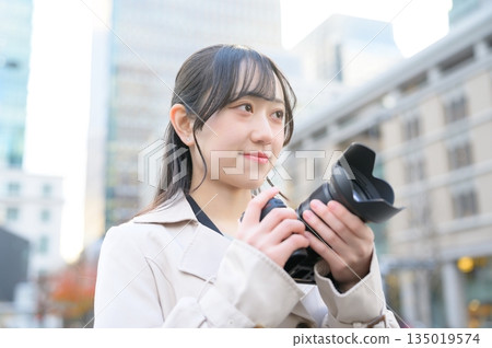Japanese woman with a camera in an office district 135019574