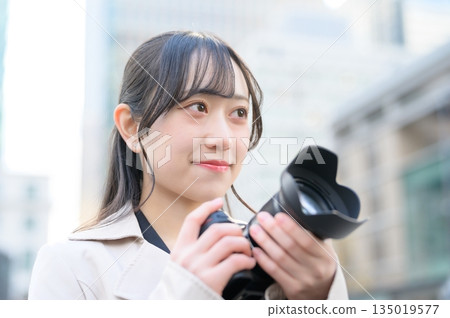 Japanese woman with a camera in an office district 135019577