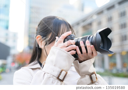 Japanese woman with a camera in an office district 135019580