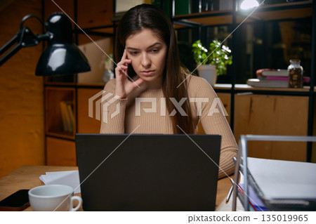 Woman experiencing digital fatigue while working late on laptop. Woman experiencing digital fatigue while working late on laptop. 135019965
