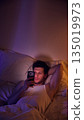 Man using smartphone while resting in bed at night. 135019973