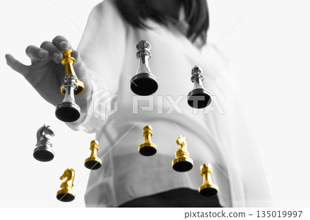 Businesswoman choosing golden chess piece among silver figures. Businesswoman choosing golden chess piece among silver figures. 135019997
