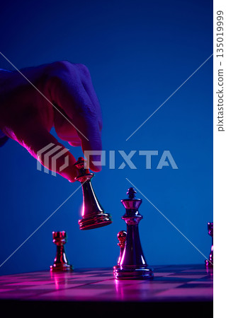 Fingers lifting chess bishop during decisive move 135019999