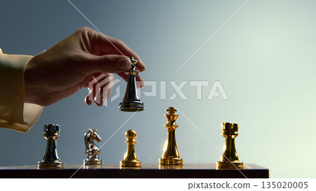 Hand lifting gold queen to signal priority move. 135020005