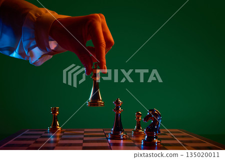 Decisive chess action as black queen is placed on board. 135020011