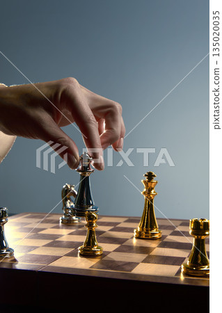 Final chess move with hand lowering queen into position. 135020035