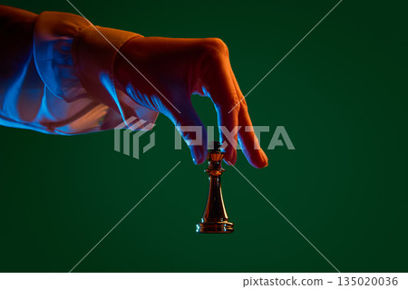 Hand moving queen across chessboard during match. 135020036