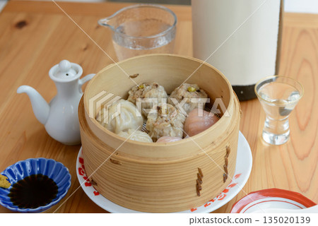 Assorted dim sum of xiaolongbao and shumai served in a bamboo steamer 135020139