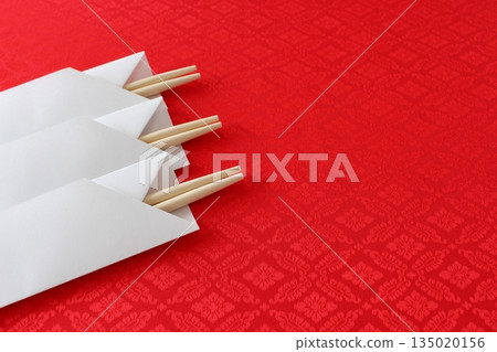 Celebration chopsticks (simple, round chopsticks, close-up, chopstick case, red background, copy space) Celebration chopsticks (simple, round chopsticks, close-up, chopstick case, red background, copy space) 135020156