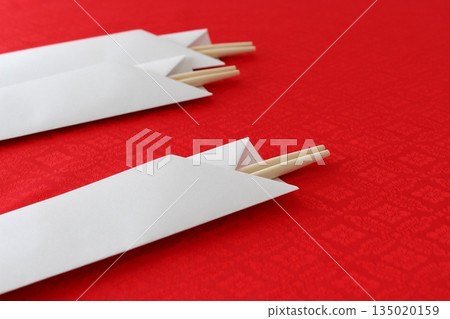 Celebration chopsticks (simple, round chopsticks, close-up, chopstick case, red background, copy space) 135020159
