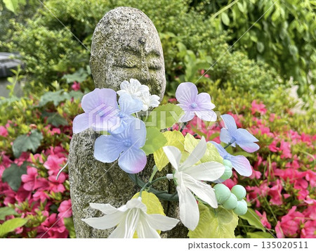 Japanese stone Buddha and early summer garden decorated with flowers Japanese stone Buddha and early summer garden decorated with flowers 135020511