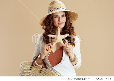 happy stylish woman in blouse and shorts isolated on beige 135020643