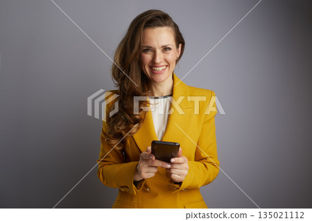 Confident Businesswoman Holding Smartphone Confident Businesswoman Holding Smartphone 135021112