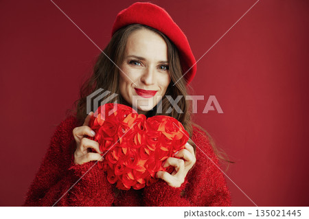 smiling trendy woman in red sweater and beret with red heart 135021445