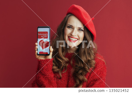 smiling woman with long wavy hair, smartphone and Valentine app 135021452