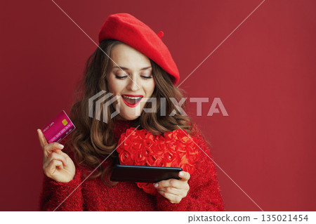 surprised stylish woman with red heart browsing online shop 135021454