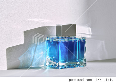Blue perfume bottle standing in light and shadow 135021719