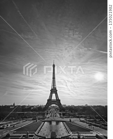 Stunning black and white Paris scene with the Eiffel Tower silhouette against a hazy sunset sky, with a look down over the Jardins du Trocadero fountains and toward Champ de Mars 135021982