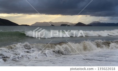 Stormy Mediterranean coastline in Fethiye with crashing waves, dark clouds, and dramatic light, capturing the raw power of nature and turbulent sea conditions. 135022018