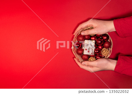 Christmas Basket with Red and Gold Decorations on Red Background 135022032