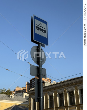 Parking sign against clear blue sky with urban building background 135022237