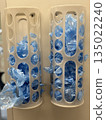 Plastic bag holders filled with blue bags in modern kitchen background 135022240