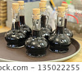 Bottles of balsamic vinegar on tray in rustic kitchen setting 135022255