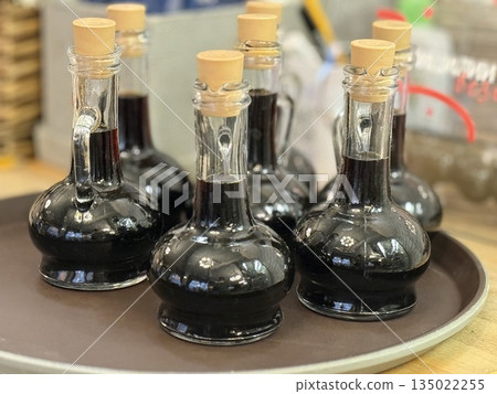 Bottles of balsamic vinegar on tray in rustic kitchen setting Bottles of balsamic vinegar on tray in rustic kitchen setting 135022255